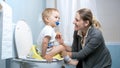 Young mother smiling after her toddler boy used toilet