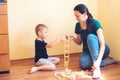 Young mother and son playing with wooden blocks indoor. Happy family spends time together at home. Royalty Free Stock Photo