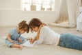 A young mother spends time with her little daughter at home.