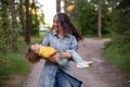 young mother is spinning with a baby in her arms. happy mom dancing with toddler on the background of nature and forest