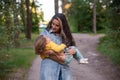 young mother is spinning with a baby in her arms. happy mom dancing with toddler on the background of nature and forest