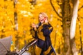 A young mother with a stroller is talking on her mobile phone while walking in the park Royalty Free Stock Photo