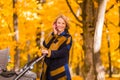 A young mother with a stroller is talking on her mobile phone while walking in the park Royalty Free Stock Photo