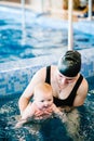 Young mother, swimming instructor and happy little girl in the pool. Teaches infant child to swim. Enjoy the first day of swimming Royalty Free Stock Photo