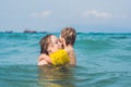 Young mother swimming and playing with male child boy in sea or ocean water sunny day outdoor on natural background, horizontal pi Royalty Free Stock Photo