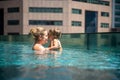 Young mother swimng with her little toddler daughter in the pool on the roof of a skyscraper in a metropolis Royalty Free Stock Photo