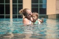 Young mother swimng and kissing her little toddler daughter in the city pool Royalty Free Stock Photo