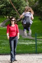 Young mother swing a child in playground Royalty Free Stock Photo