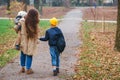 Young mother taking child to school, and baby son to kindegarden. Autumn time change. Parent, baby son, son schoolboy. Happy