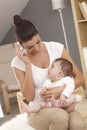 Young mother talking on mobile baby watching Royalty Free Stock Photo