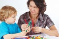 Young mother teaches her child to draw with color pencils Royalty Free Stock Photo