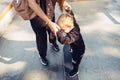 Young mother teaches her little boy to ride a skateboard