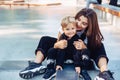 Young mother teaches her little boy to ride a skateboard