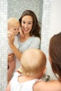 Young mother teaching cute baby how to brush teeth with toothbrush