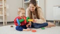 Young mother teaching her little baby son building colorful toy pyramid at home. Baby development, child playing games, education Royalty Free Stock Photo