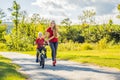 Young mother teaching her son how to ride a bicycle in the park Royalty Free Stock Photo