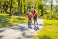 Young mother teaching her son how to ride a bicycle in the park Royalty Free Stock Photo