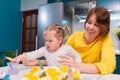 Young mother teaching little daughter are painting Easter eggs. Funny family leisure. Concept of preschool education