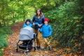 Young mother of three children, going for a walk with stroller i