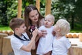 Young mother and three children in the Park. Eldest son is taking pictures siblings. Big happy family Royalty Free Stock Photo