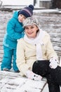 Young mother with toddler boy sitting on bench in winter park. Woman playing and hugging with cute baby son. Royalty Free Stock Photo