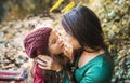 A young mother with a toddler daughter hugging and kissing in forest in autumn nature. Royalty Free Stock Photo