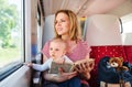 Young mother travelling with baby by train. Royalty Free Stock Photo