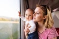 Young mother travelling with baby by train. Royalty Free Stock Photo