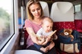 Young mother travelling with baby by train. Royalty Free Stock Photo