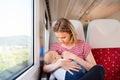 Young mother travelling with baby by train. Royalty Free Stock Photo