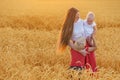 Young mother with two children in middle of wheat field. Happy family Royalty Free Stock Photo