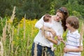 Young mother with two children in a yellow flower field Royalty Free Stock Photo