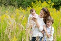 Young mother with two children in a yellow flower field Royalty Free Stock Photo