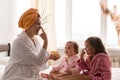 Young mother two daughters in curlers bathrobes. happy smiling family skin care concept. Mom teaches little kids child Royalty Free Stock Photo