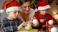 Young mother with two kids preparing for Christmas and making handmade decorations. Winter holidays, family time Royalty Free Stock Photo