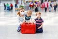 Young mother with two little kid boys at airport. Cute preschool children, siblings, twins and woman, family traveling