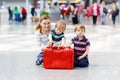 Young mother with two little kid boys at airport. Cute preschool children, siblings, twins and woman, family traveling