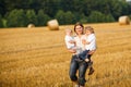 Young mother and two little twins boys having fun on yellow hay Royalty Free Stock Photo