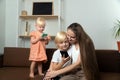 Young mother and two small children with phones in their hands. Mom hugs her son and looks at his phone Royalty Free Stock Photo