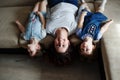 a young mother and two young daughters are lying on the sofa upside down Royalty Free Stock Photo