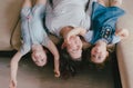 a young mother and two young daughters are lying on the sofa upside down Royalty Free Stock Photo