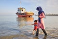 Young mother walking with her son on shores Persian Gulf. Royalty Free Stock Photo