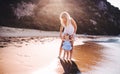 Young mother with a toddler girl on beach on summer holiday at sunset. Royalty Free Stock Photo