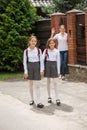 Young mother waving with hand to her daughters going to school Royalty Free Stock Photo