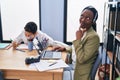 Young mother wearing call center agent headset serious face thinking about question with hand on chin, thoughtful about confusing Royalty Free Stock Photo