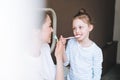 Young mother woman with long hair with little tween girl daughter in pajamas brushing their teeth in the morning at home Royalty Free Stock Photo