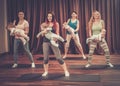 Young mothers and their babies doing yoga exercises on rugs at fitness studio. Royalty Free Stock Photo