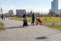 Young mothers walk with small children in a public garden, on the background of the Krasnoyarsk city