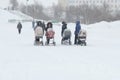 Young mothers are walking with strollers in a snowstorm Royalty Free Stock Photo