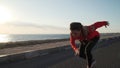 Young motivated girl is preparing to run on promenade at sunsetin nature.